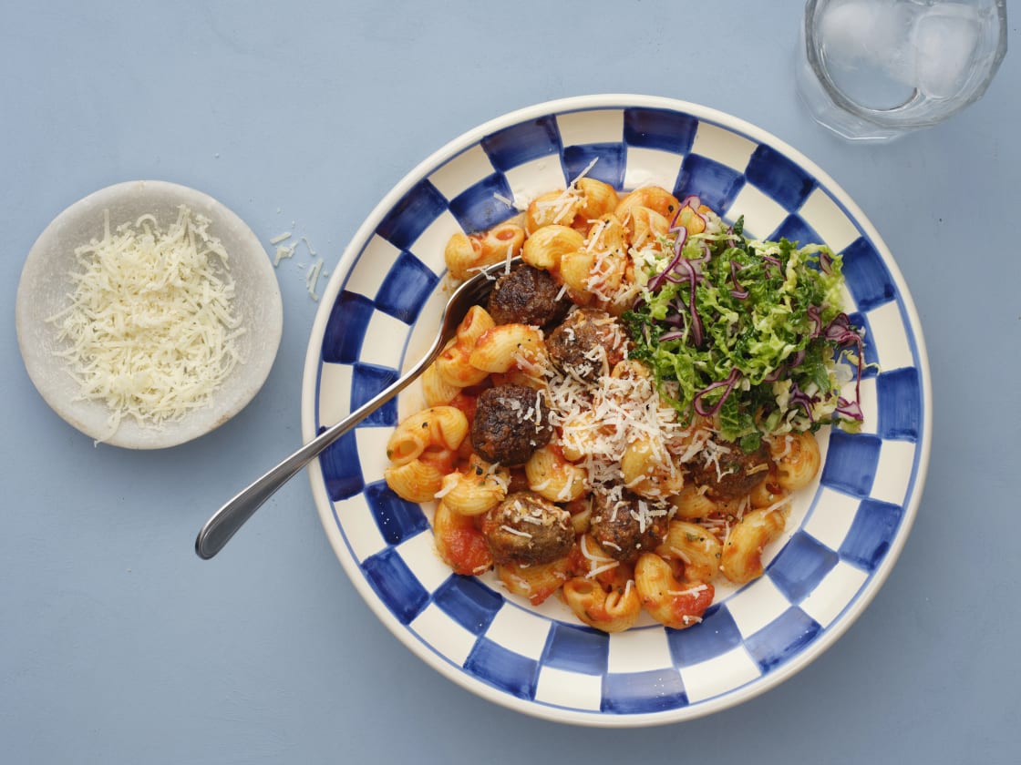 Tallrik med pasta, köttbullar och sallad.