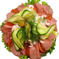 En tallrik med skivad skinka, grönsaker och räkor arrangerade i en cirkel.