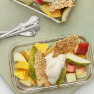 Fruktsallad med kvarg och sesamkrisp upplags i glasmatlådor