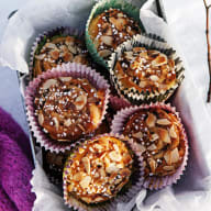 Muffins med frön ligger på ett papper bredvid en gren och ett tygstycke.