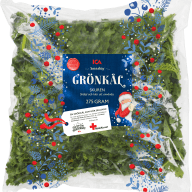 En förpackning med grönkål från ICA visas med julmotiv och information om Röda Korset på etiketten.