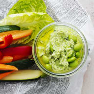 Green goddess-röra i en skål med grönsaksstavar och salladsblad omkring