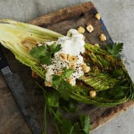 Grillad romansallad toppad med en klick krämig ädeloströra och rostade hasselnötter.