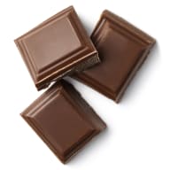 Tre bitar choklad ligger bredvid varandra på en yta.
