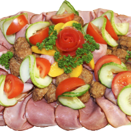 En tallrik med skivad skinka, grönsaker och kött arrangerade i ett mönster.