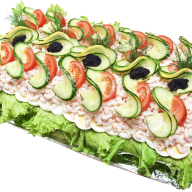 En smörgåstårta med grönsaker och salladsblad ligger på ett fat.