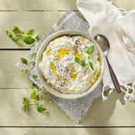 En skål med härligt krämig Tzatziki på yoghurt, riven gurka och pressad vitlök, toppad med mycket olivolja och nymalen svartpeppar.