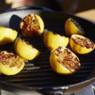 Citronhalvor och hela citroner grillas på ett grillgaller.