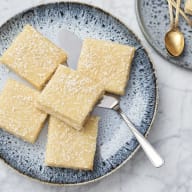 Silviakaka med kokos på toppen. kakorna ligger på ett blått fat.