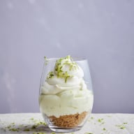 En key lime pie i glas. I botten ligger kaksmulor seda själva moussen och på toppen lite rivet limeskal.