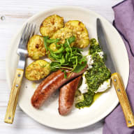 Parmesanrostad färskpotatis, med salsiccia och pistou på en tallrik. Rätten är toppad med ricotta och rucola.