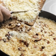 Parmesan som hälls i en risotto.