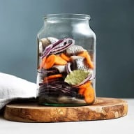 Sill och grönsaker i en glasburk