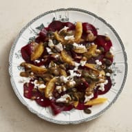 En tallrik med sallad bestående av grönsaker och ost serveras på en ljus yta.
