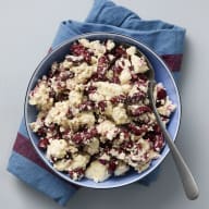 En skål med bön- och fetaoströra och en sked står på en duk.