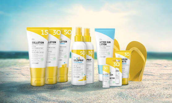 ICAs solprodukter på en strand med flipflops.