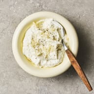 Pepparrotsyoghurt ligger i en skål med en sked i.