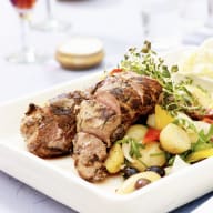 En tallrik med kött och grönsaker serveras på ett bord.