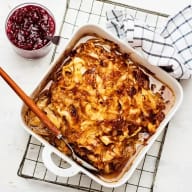 KÅlpudding i ugnsform på ett ugnsgaller. En skål med lingonsylt bredvid.