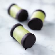 Tre cylinderformade godisbitar ligger på en ljus yta.