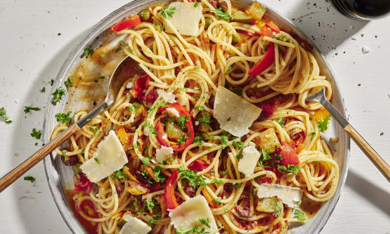 En tallrik pasta med pastasås och hyvlad parmigiano reggiano.