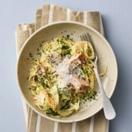 En tallrik med pasta och en gaffel ligger på en tygservett.