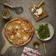 nygräddad pizza med råvaror runt om