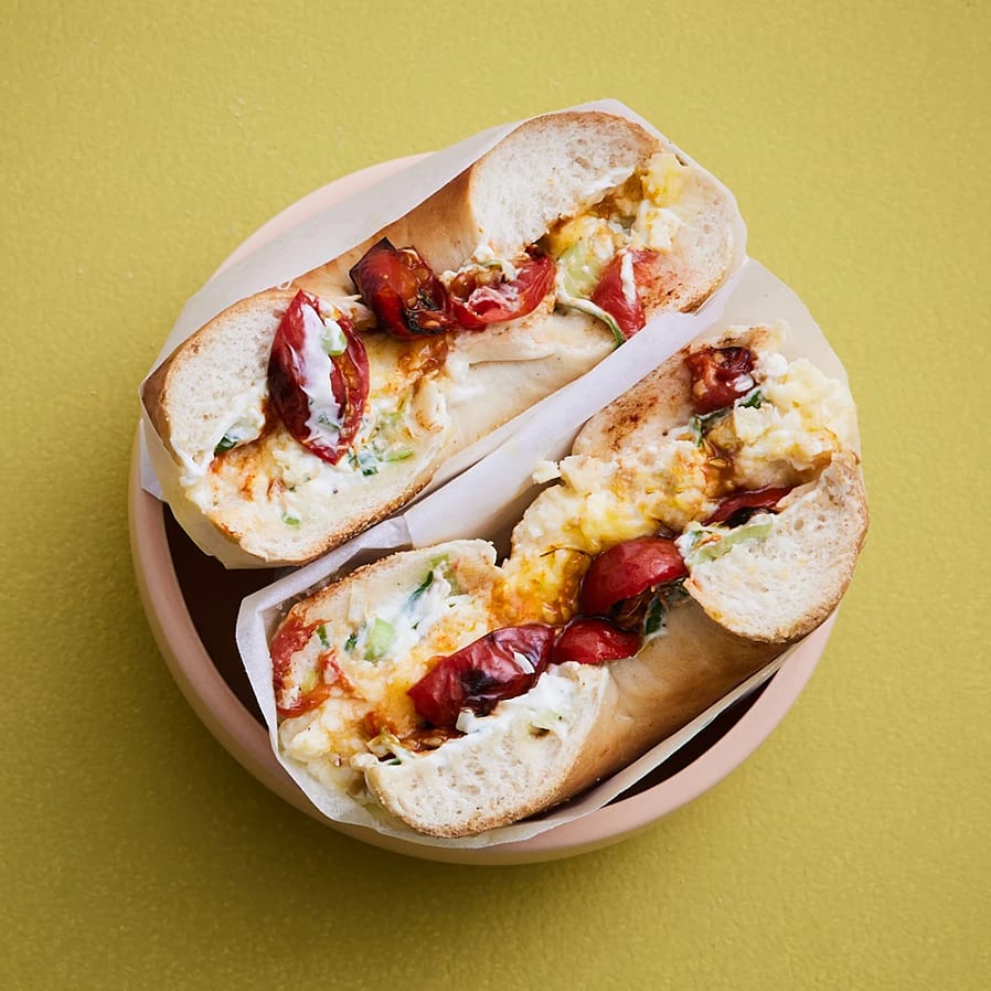 Bagel med cheddaromelett, bakade tomater och lökschmear