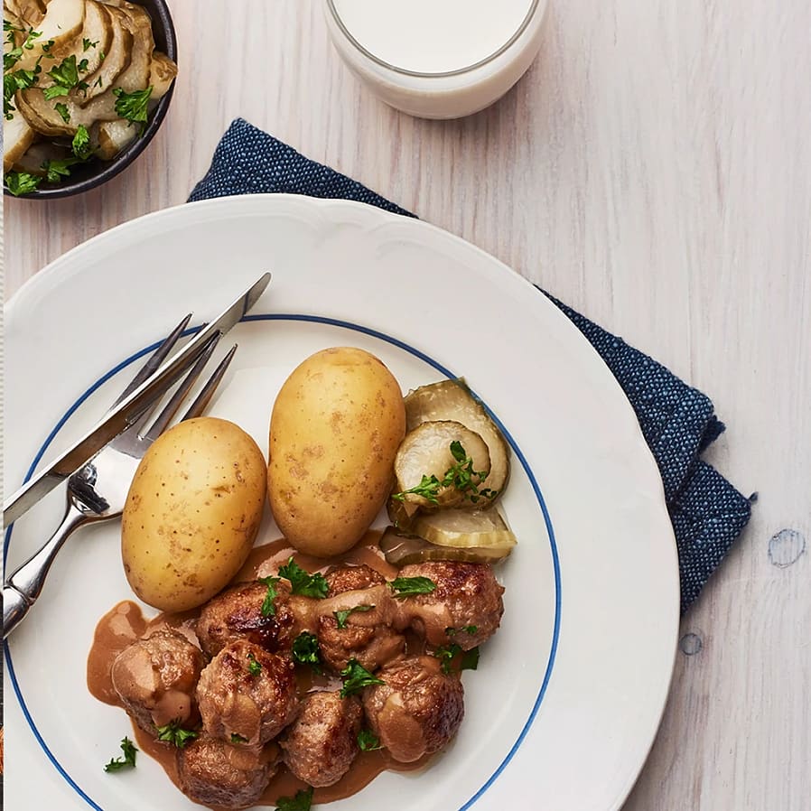 Köttbullar med gräddsås, picklad gurka och persilja