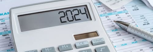 Miniräknare på ett papper med ekonomiska siffror