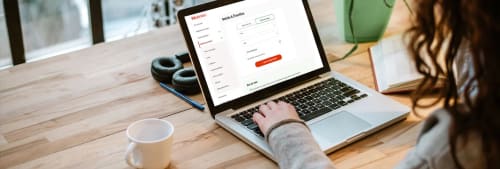 En bärbar dator på ett bord som visar ICA Bankens internetbank