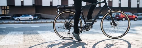 En man som står still sittandes på en elcykel.
