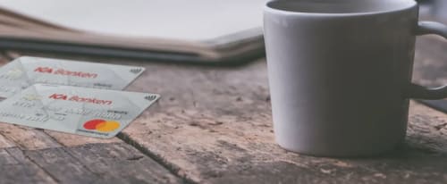 Två kort på ett cafébord - bankkort eller kreditkort