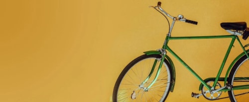 En grön cykel i ett gult rum.