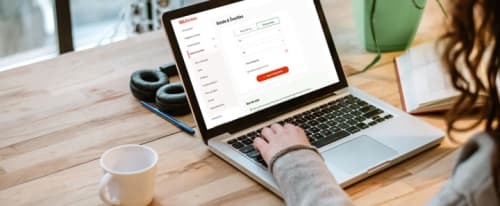 En bärbar dator på ett bord som visar ICA Bankens internetbank