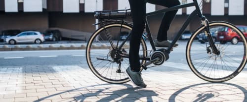 En man som står still sittandes på en elcykel.