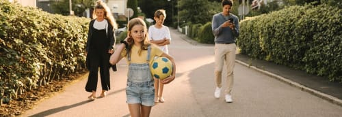 Familj går på en solig villagata