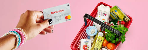 En hand med bankkort och varukorg på ICA
