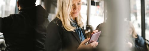 Kvinna som tittar på en mobiltelefon.