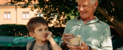 En äldre man äter glass med sitt barnbarn
