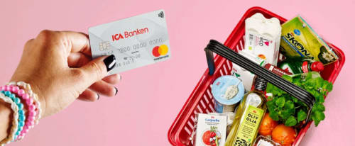 En hand med bankkort och varukorg på ICA