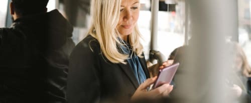 Kvinna som tittar på en mobiltelefon.