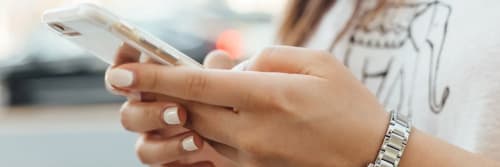 Kvinna som skriver på en mobil - Nu finns förfrågningar i Swish