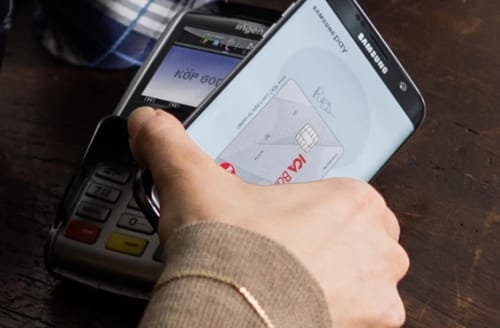 Person betalar med mobilen och Samsung pay