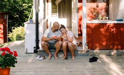 Bild på en pappa och dotter som sitter utanför ett torp 