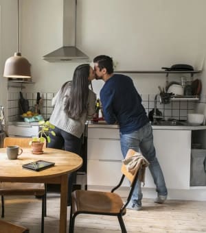 Par som står i köket och pussar varandra.