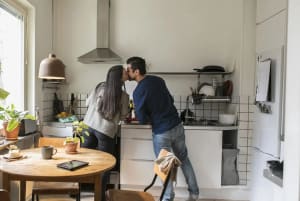 Par som står i köket och pussar varandra.