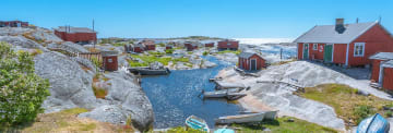 Skärgårdsvy med röda stugor vid havet