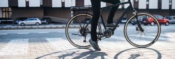En man som står still sittandes på en elcykel.