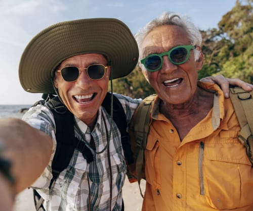 Två pensionärer tar en selfie. Pensionspara för tryggare pension.